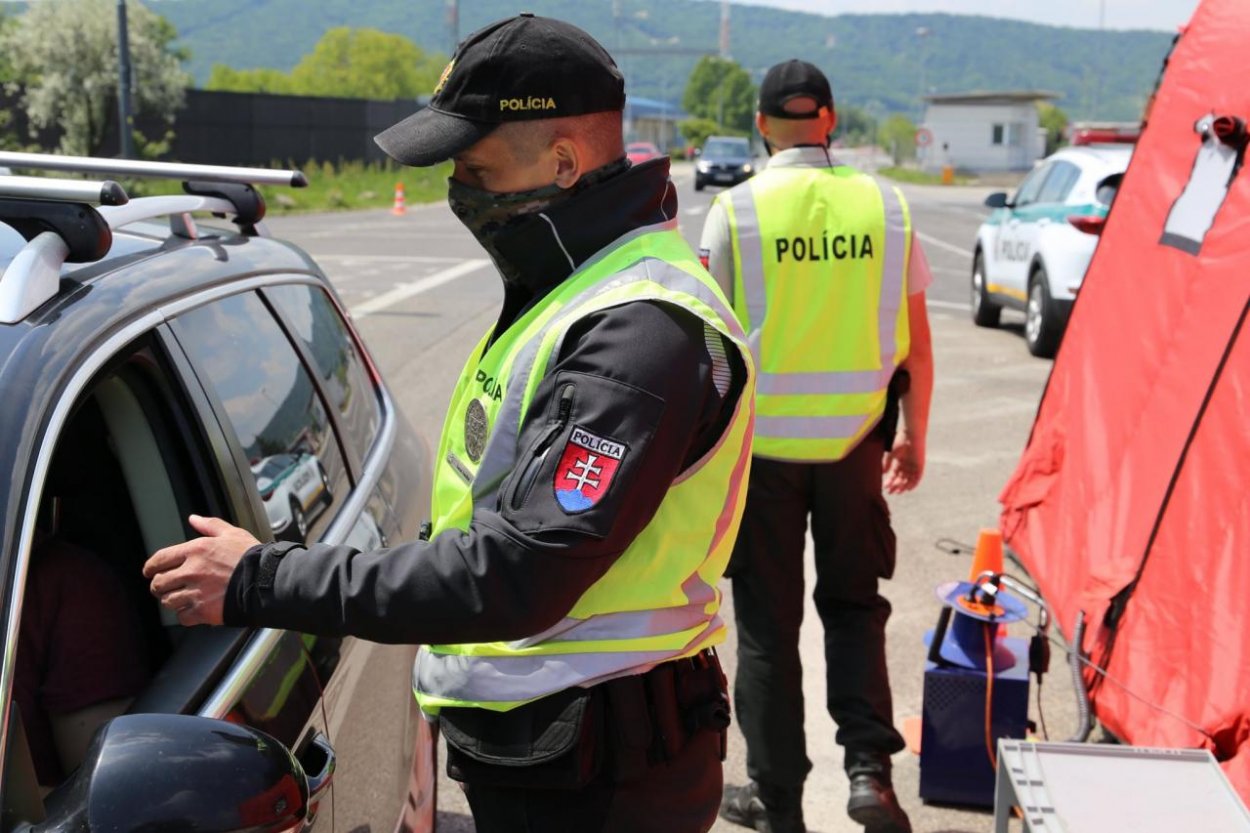 Policajti na hraniciach kontrolujú cestujúcich, majú pomôcť bojovať proti šíreniu koronavírusu